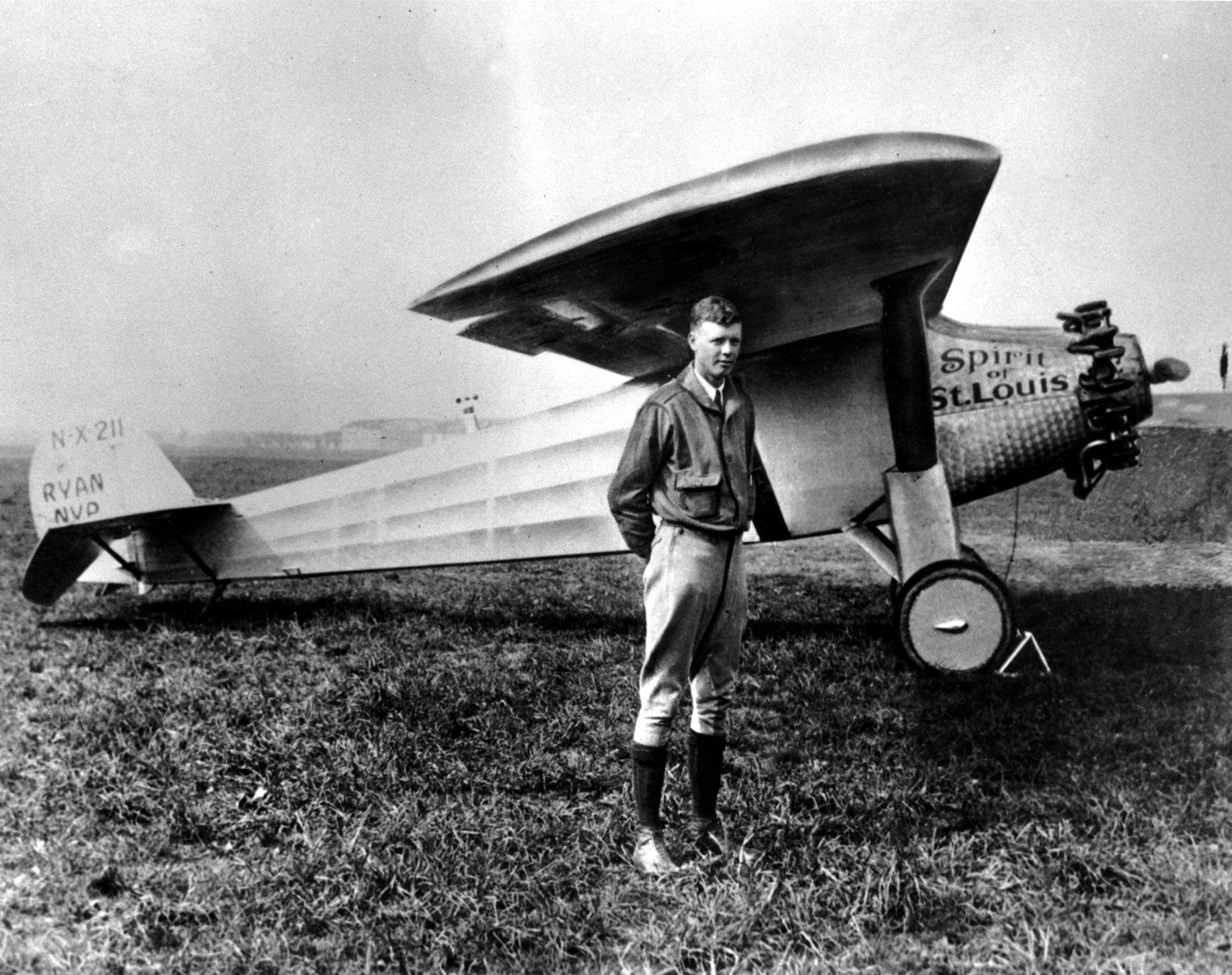 FILE - In this 1927 file photo, Charles A. Lindbergh poses with his plane "The Spirit of St. Louis." Lindberghs Spirit of St. Louis aircraft, one of the premiere artifacts at the National Air and Space Museum in Washington, was lowered to the floor Thursday, for conservation work for the first time in more than 20 years, giving visitors a rare chance to see it up close. When Lindbergh made the first trans-Atlantic flight and landed in Paris in 1927, crowds swarmed the aircraft, tearing off pieces for souvenirs. (AP Photo, File)